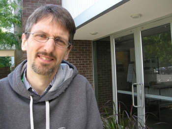 John Aston standing outside of the NISS building