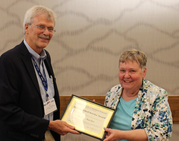 Mary Batcher receiving the NISS Distinguished Service Award from Jim Rosenberger.