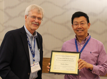 Dr. Haibo Zhou receives the 2019 NISS Distinguished Alumni Award from Jim Rosenberger.